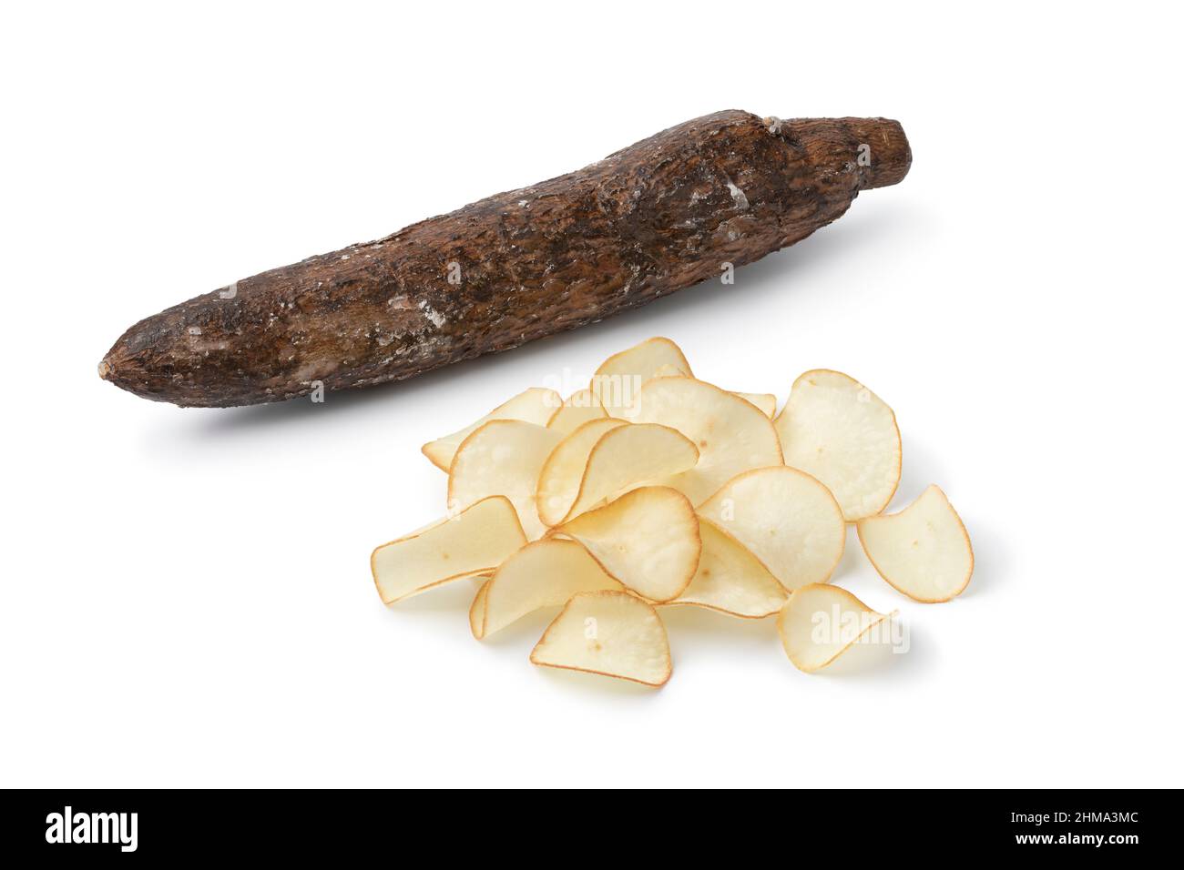 Haufen knusprig frittierter Cassava-Chips und ganzer Cassava Nahaufnahme isoliert auf weißem Hintergrund Stockfoto