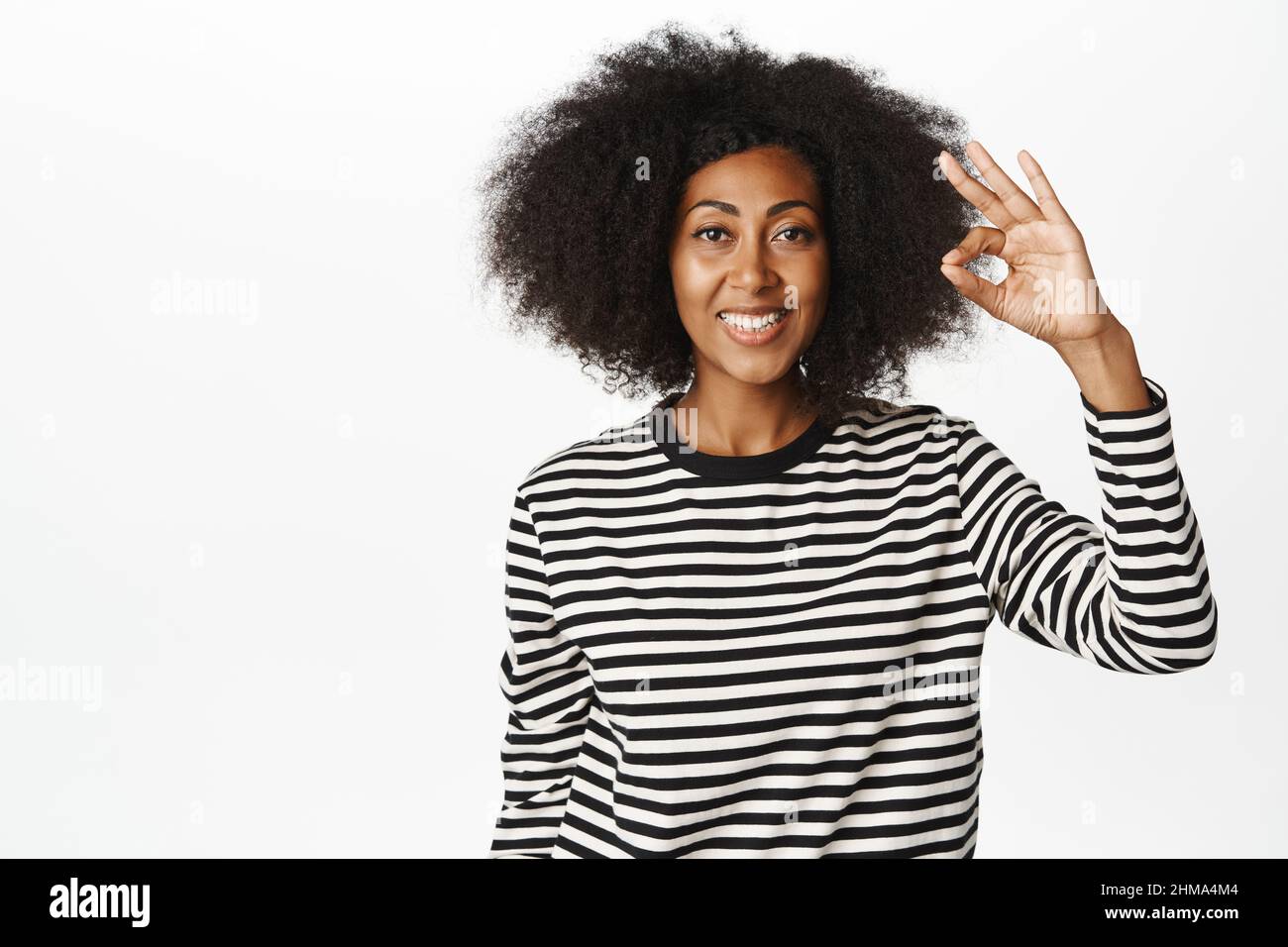 Okay, Sehr gut. Lächelndes afroamerikanisches Frauenmodell, zeigt ok, Null-Geste, Lob smth, Kompliment, Empfehlen brad oder Geschäft, weiß Stockfoto
