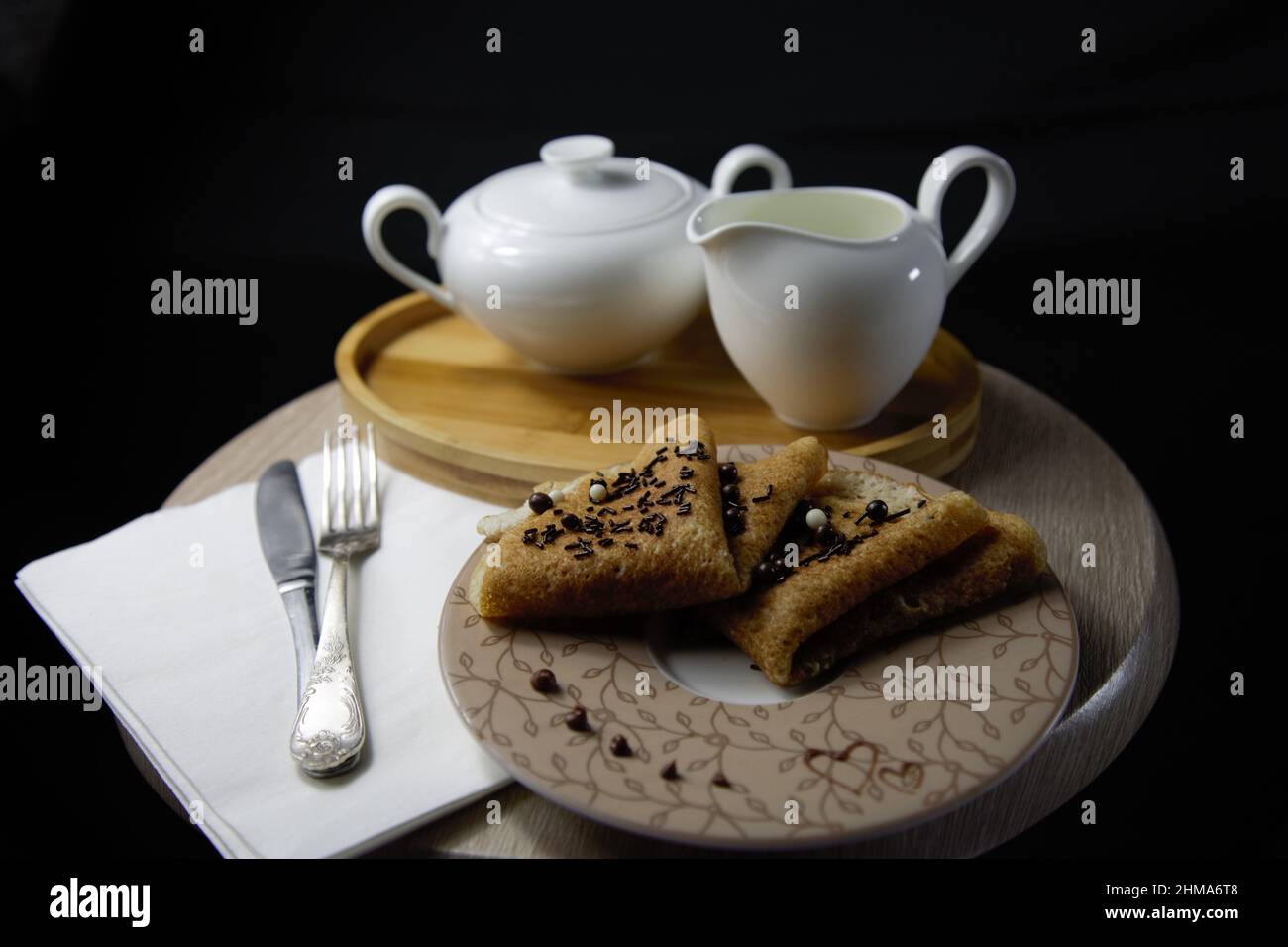 Pfannkuchen zum Frühstück mit Schokoladenstreuseln und Milch. Stockfoto