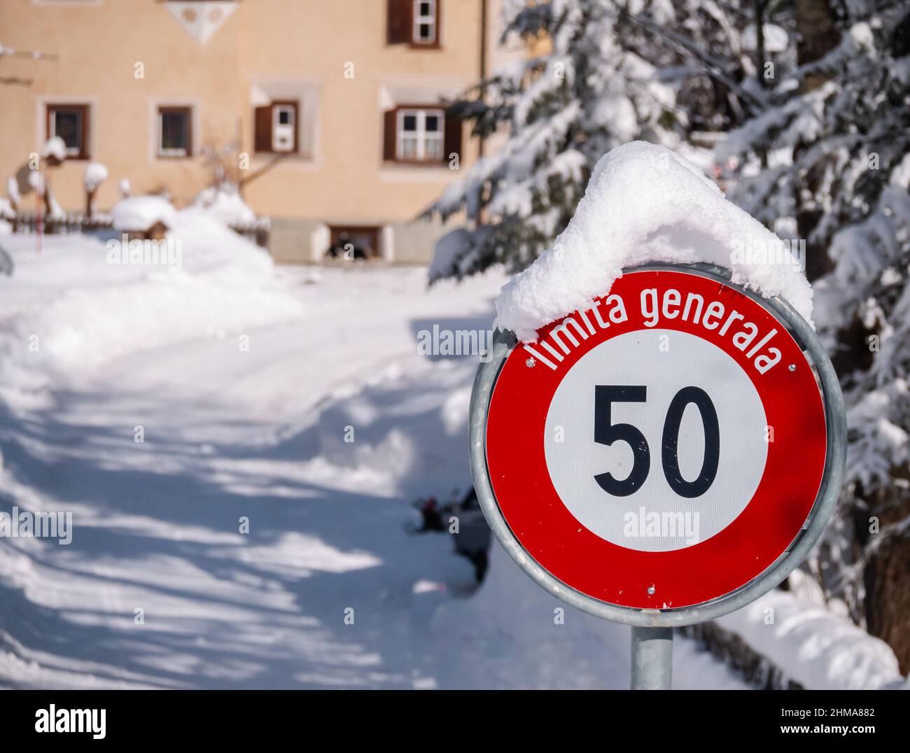 Cinuos-Chel, Schweiz - 3. Februar 2022: Schneebedecktes Straßenschild für Geschwindigkeitsbegrenzung auf 50 km in romanischer Sprache im schweizer Dorf Cinuos-CH Stockfoto