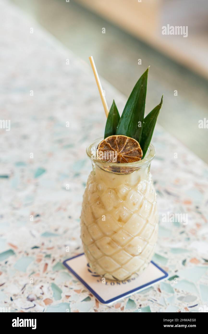 Fruchtiger Ananas-Kokosnuss-Rum-Cocktail an einer recycelten Glasbar Stockfoto