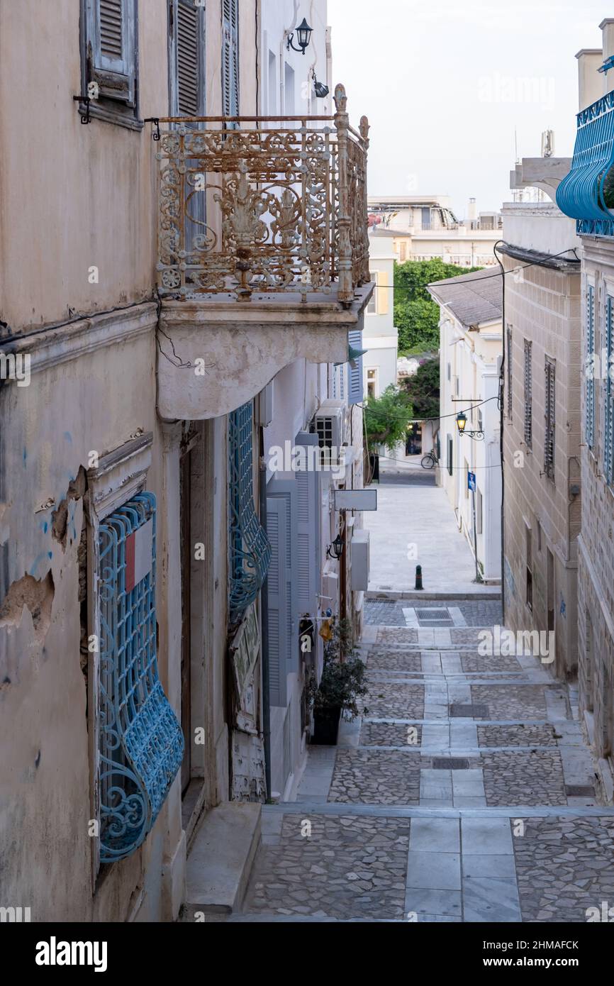 Griechenland. Ermoupolis Syros, Kykladen. Schmale Straße, gepflasterter Treppenaufgang und Balkon, traditionelle Architektur Stockfoto