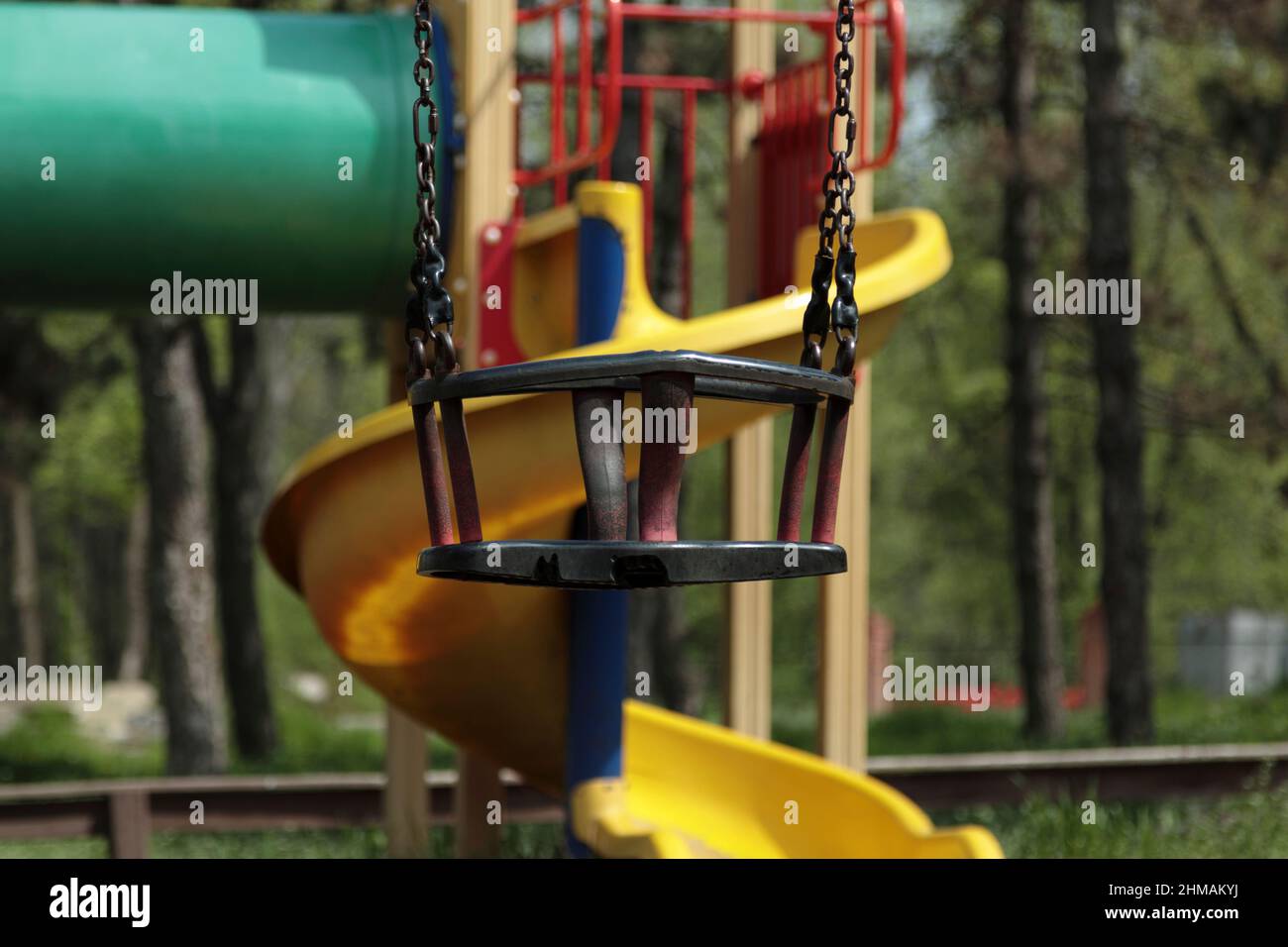 Kinderschaukel an einer Kette. Nahaufnahme. Der Hintergrund ist unscharf. Stockfoto Kinderschaukel an einer Kette. Nahaufnahme. Der Hintergrund ist unscharf. Stockfoto