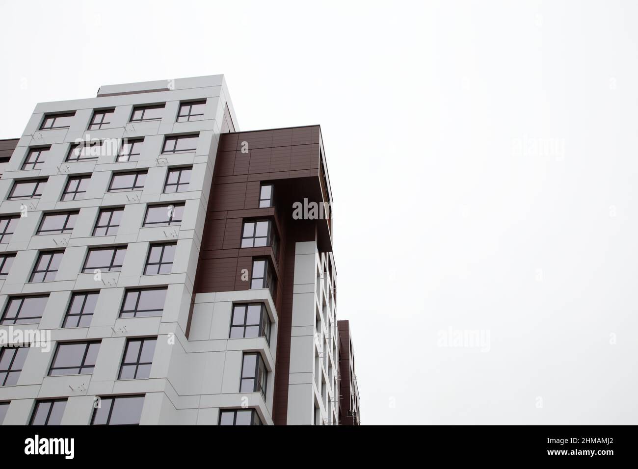 Modernes Apartmentgebäude vor bewölktem Himmel. Es gibt Platz für Text. Nahaufnahme. Stockfoto Modernes Apartmentgebäude vor bewölktem Himmel. Es gibt Platz für Text. Nahaufnahme. Stockfoto