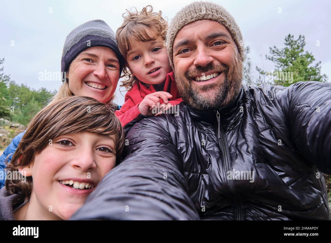 Eine glückliche Familie entspannt sich und macht Selfie in den Bergen Stockfoto