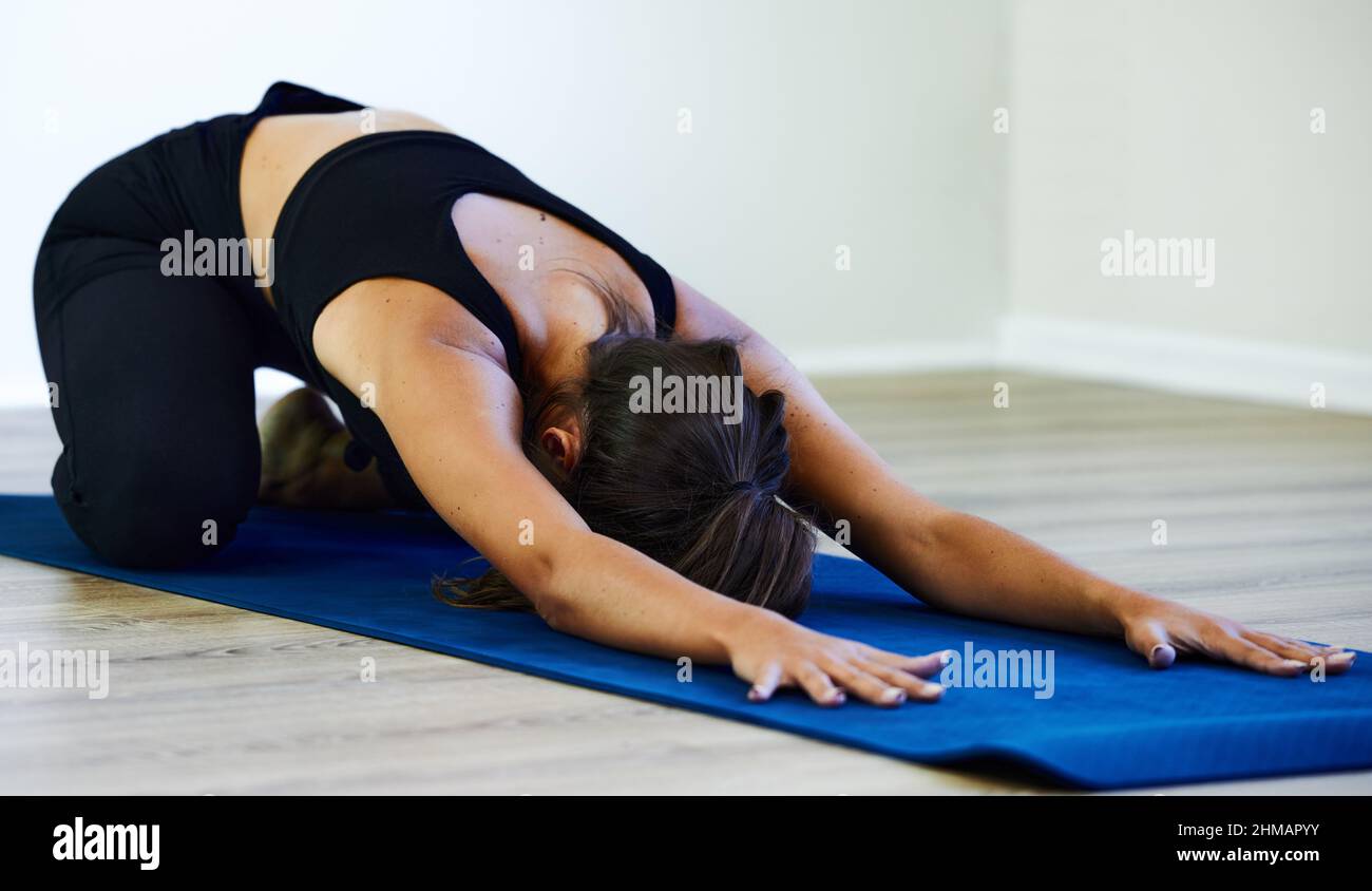 Die Haltung der Kinder ist meine Lieblingsposition. Aufnahme einer jungen Frau, die zu Hause Yoga praktiziert. Stockfoto