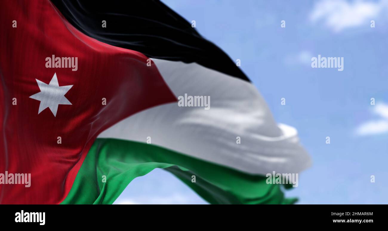 Detail der Nationalflagge Jordaniens, die an einem klaren Tag im Wind winkt. Patriotismus. Selektiver Fokus. Westasiatisches Land. Stockfoto
