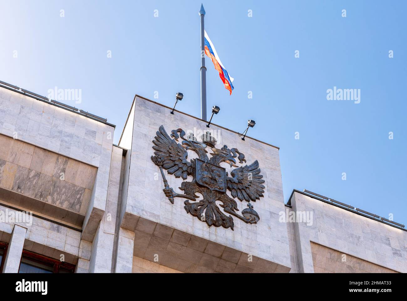 Das russische Wappen und die Staatsflagge auf dem Verwaltungsgebäude Stockfoto
