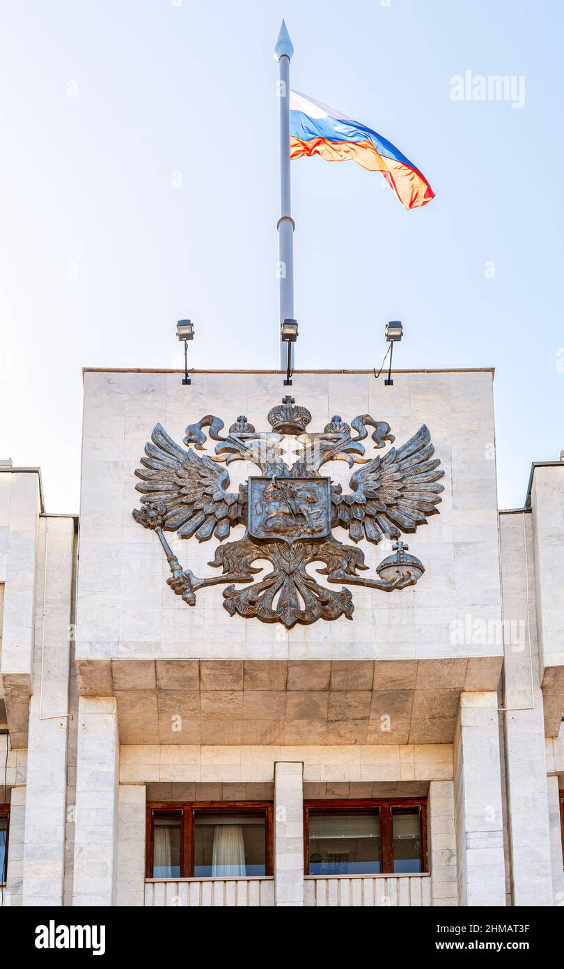 Das russische Wappen und die Staatsflagge auf dem Verwaltungsgebäude Stockfoto