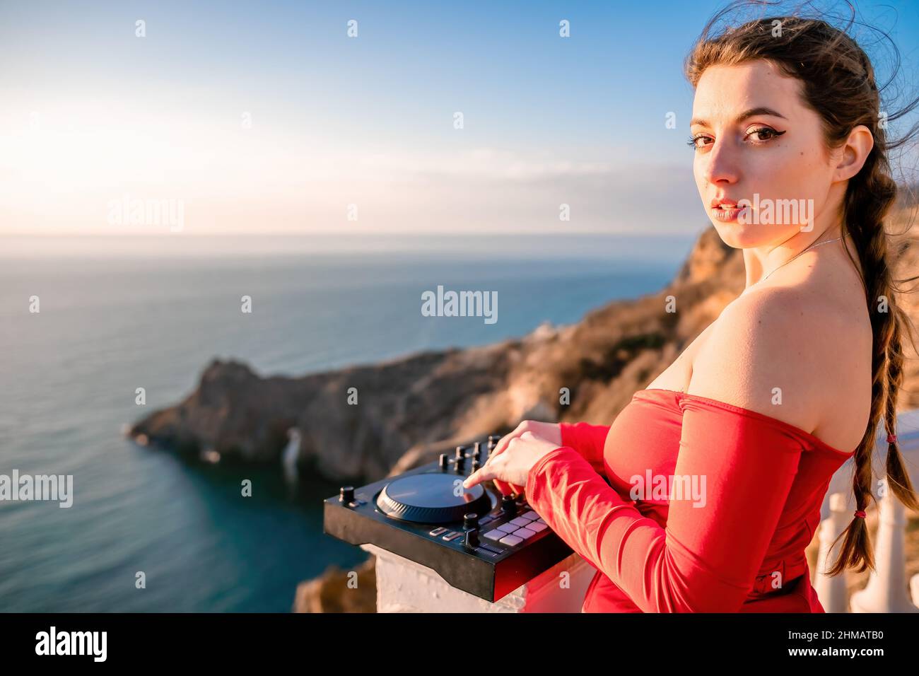 Weibliche Hände von DJ spielen Musik mischen und kratzen auf Abendparty mit Meereshintergrund und weichen warmen Sonnenuntergang. Nahaufnahme einer DJ-Konsole, die von gesteuert wird Stockfoto