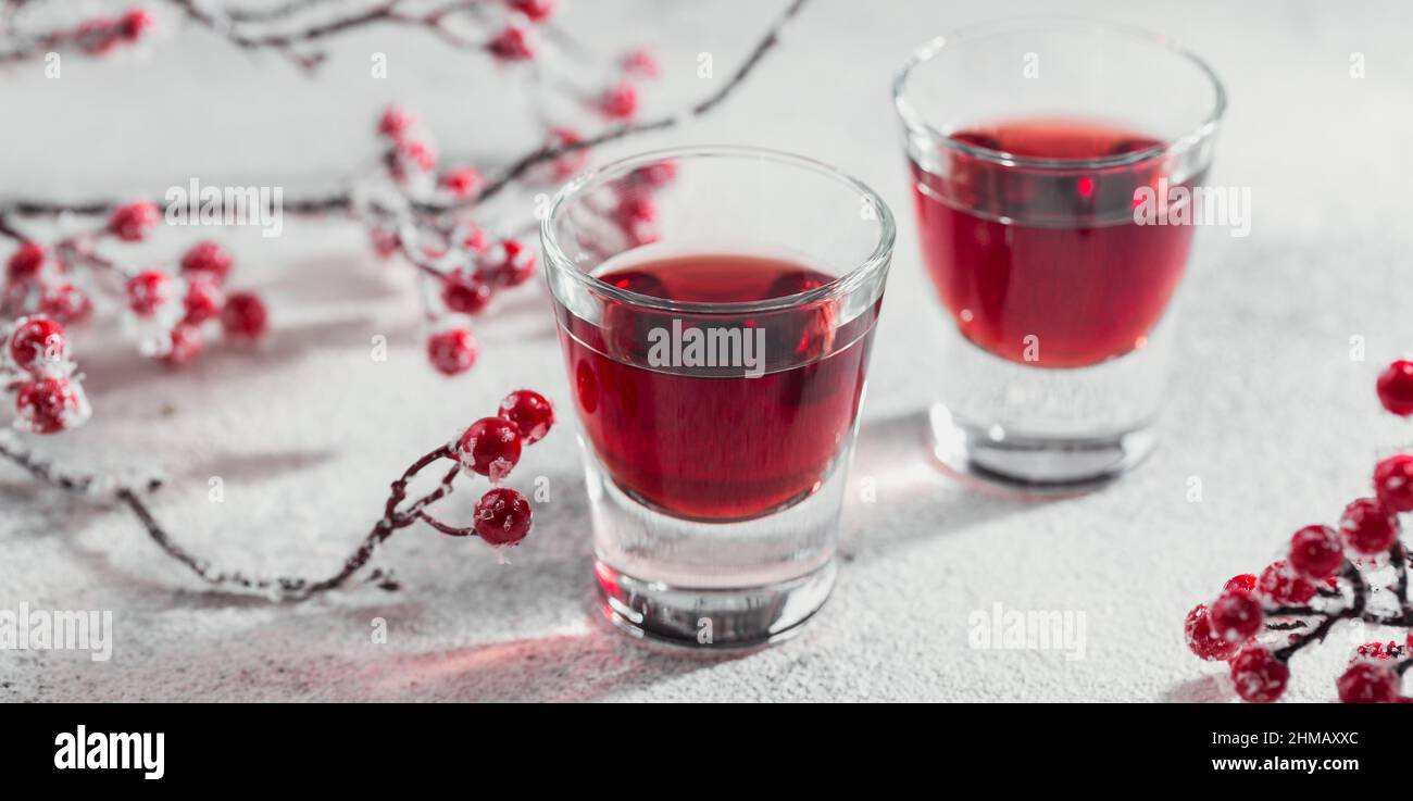 Zwei Gläser roten Cocktail, Wodka oder Likör auf hellem Hintergrund. Alkohol Shot Drink Konzept Stockfoto
