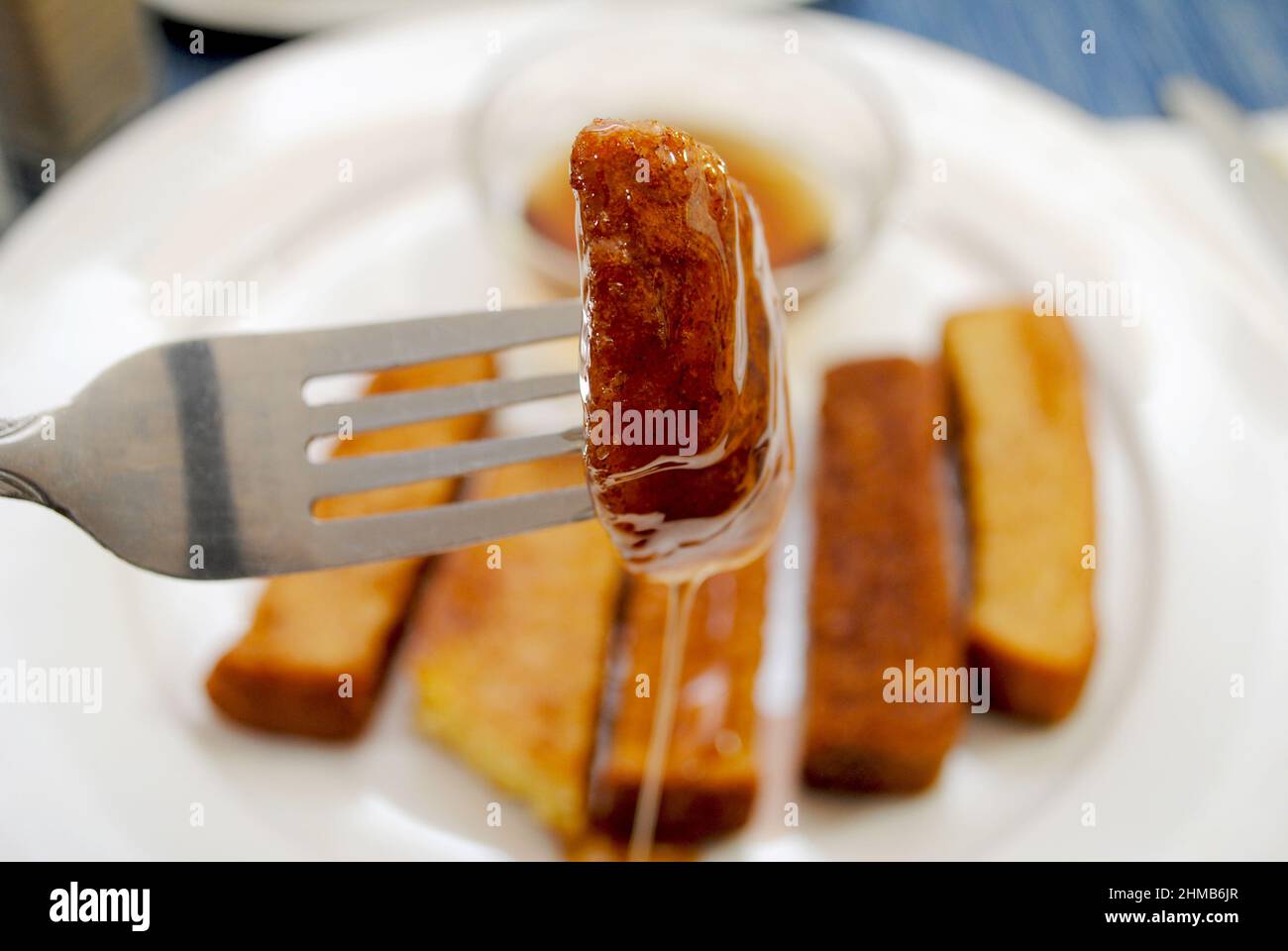 Dipping French Toast Sticks in Maple Sirup Stockfoto