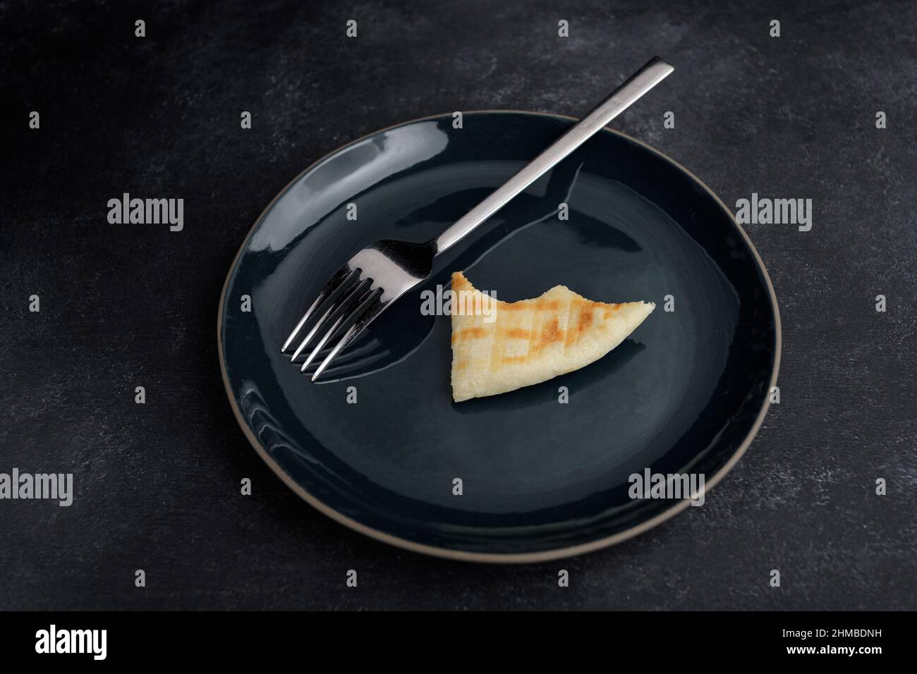 Leeren Sie den Teller mit dem abgebissenen Stück Brot und der Gabel Stockfoto