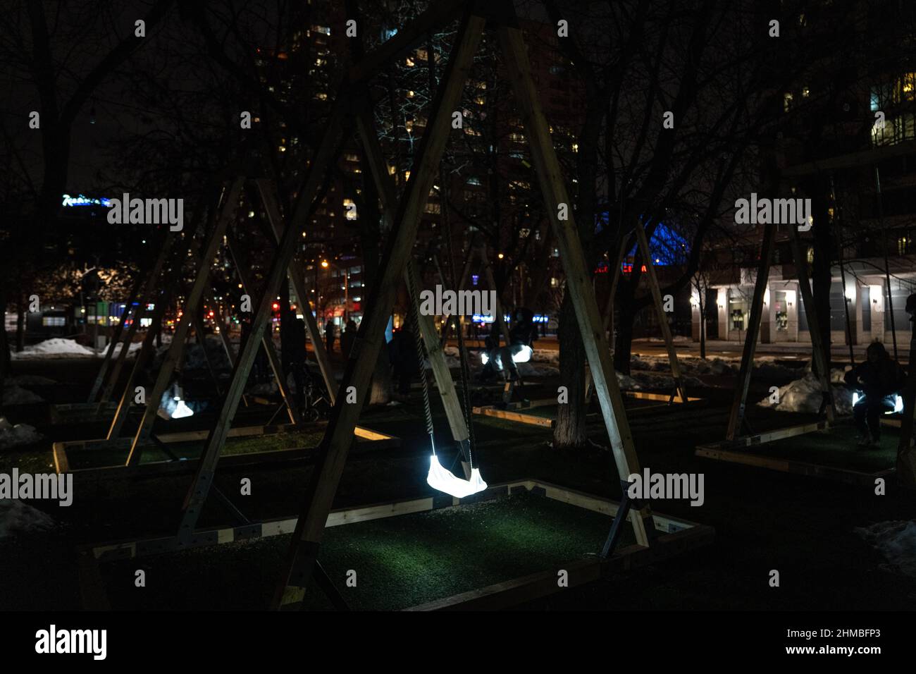 Toronto, Kanada. 07th. Februar 2022. Die Menschen spielen mit einer Lichtkunstinstallation im Freien, dem ‘Sense Light Swing' des Künstlers Alexander Lervik, einer Leuchte, die nach dem Vorbild einer hängenden Schaukel für Kinder gestaltet wurde.die Nordic Lights Outdoor-Winterausstellung, eine Ausstellung nordischer und kanadischer Lichtkunst im Toronto Harbourfront Center, die gemeinsam mit Fjord Studio produziert wurde. (Foto von Katherine Cheng/SOPA Images/Sipa USA) Quelle: SIPA USA/Alamy Live News Stockfoto