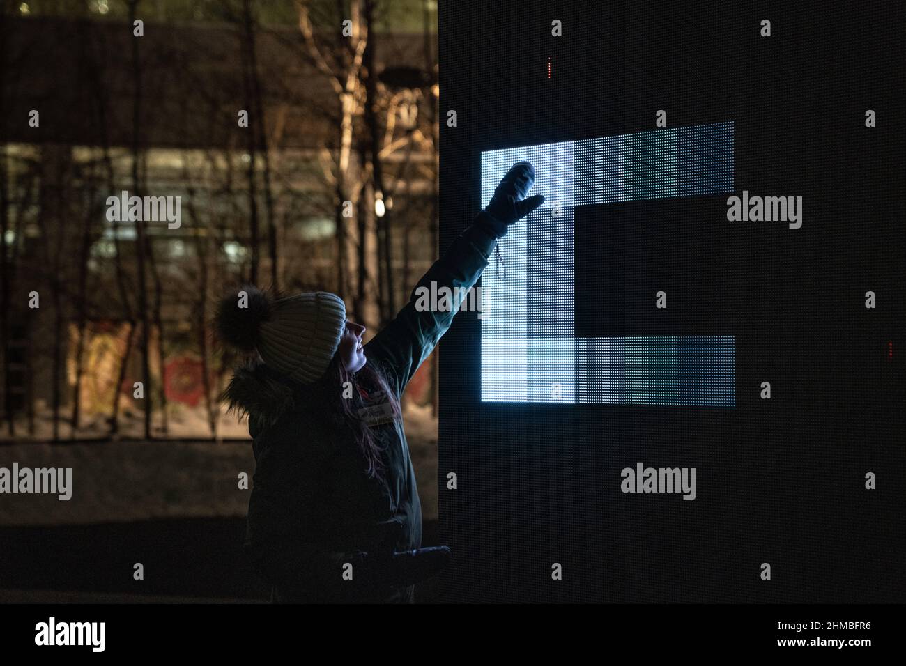 Toronto, Kanada. 07th. Februar 2022. Eine Frau nutzt ihre Hand, um mit einer Lichtkunst-Installation ‘Control No Control' von Studio Iregular zu interagieren, einem großen LED-Würfel, der auf alles reagiert, was ihn berührt, und jede Bewegung, die auf seiner Oberfläche durchgeführt wird. Eine Ausstellung nordischer und kanadischer Lichtkunst im Toronto Harbourfront Centre, die gemeinsam mit Fjord Studio produziert wurde. (Foto von Katherine Cheng/SOPA Images/Sipa USA) Quelle: SIPA USA/Alamy Live News Stockfoto