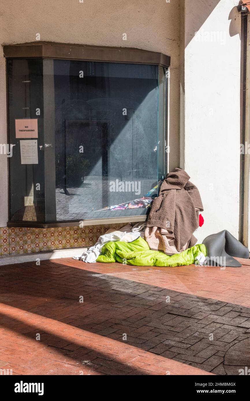 Weltliche Habseligkeiten einer obdachlosen Person, die an ihrem Platz gelassen wurde, während sie auf der State Street in Santa Barbara, Kalifornien, gegangen ist. Stockfoto