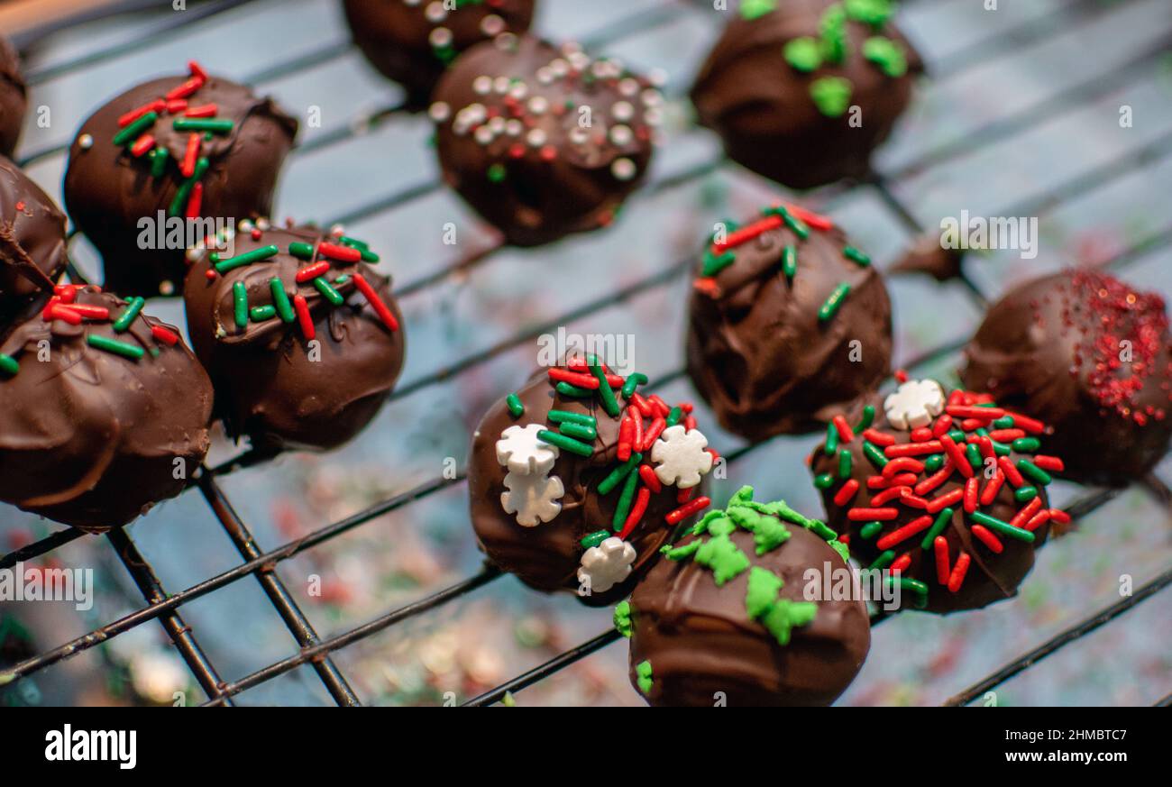Schokoladige Kuchenbällchen sind in bunten Streuseln für weihnachtliche süße Tabletts dekoriert Stockfoto