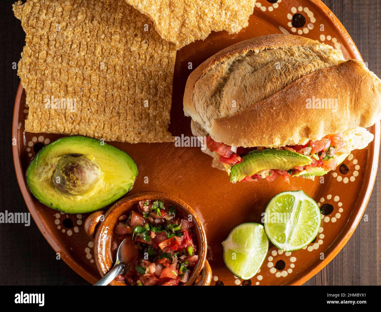 Bolillo gefüllt mit Chicarron, Avocado und mexikanischer Sauce (Guacamaya). Stockfoto