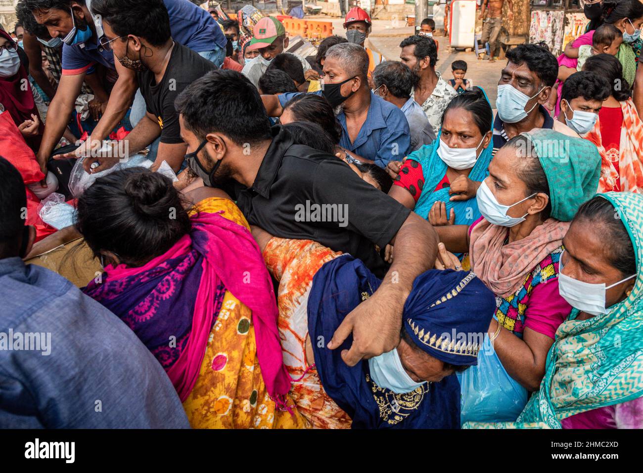 Die armen Menschen kämpfen darum, die Nahrungsmittel zu erhalten, die eine kleine lokale Organisation auf den Straßen von Dhaka verteilt.85 % der wirtschaftlich aktiven Bevölkerung des Landes sind im informellen Sektor ohne jegliche soziale Sicherheit beschäftigt, Dieser Sektor war aufgrund der Schließung vieler Aktivitäten und der limitierten Bewegungen der am stärksten von der Pandemie geschädigte Sektor. Stockfoto