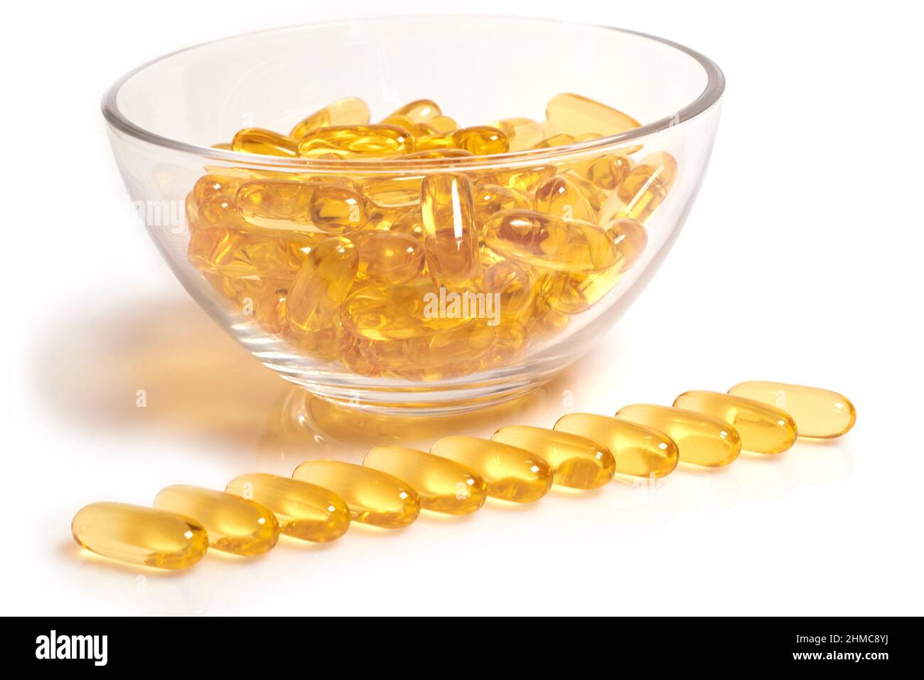 Gelbe Omega-3-Fischöl-Kapseln in einer Glasschale Stockfoto