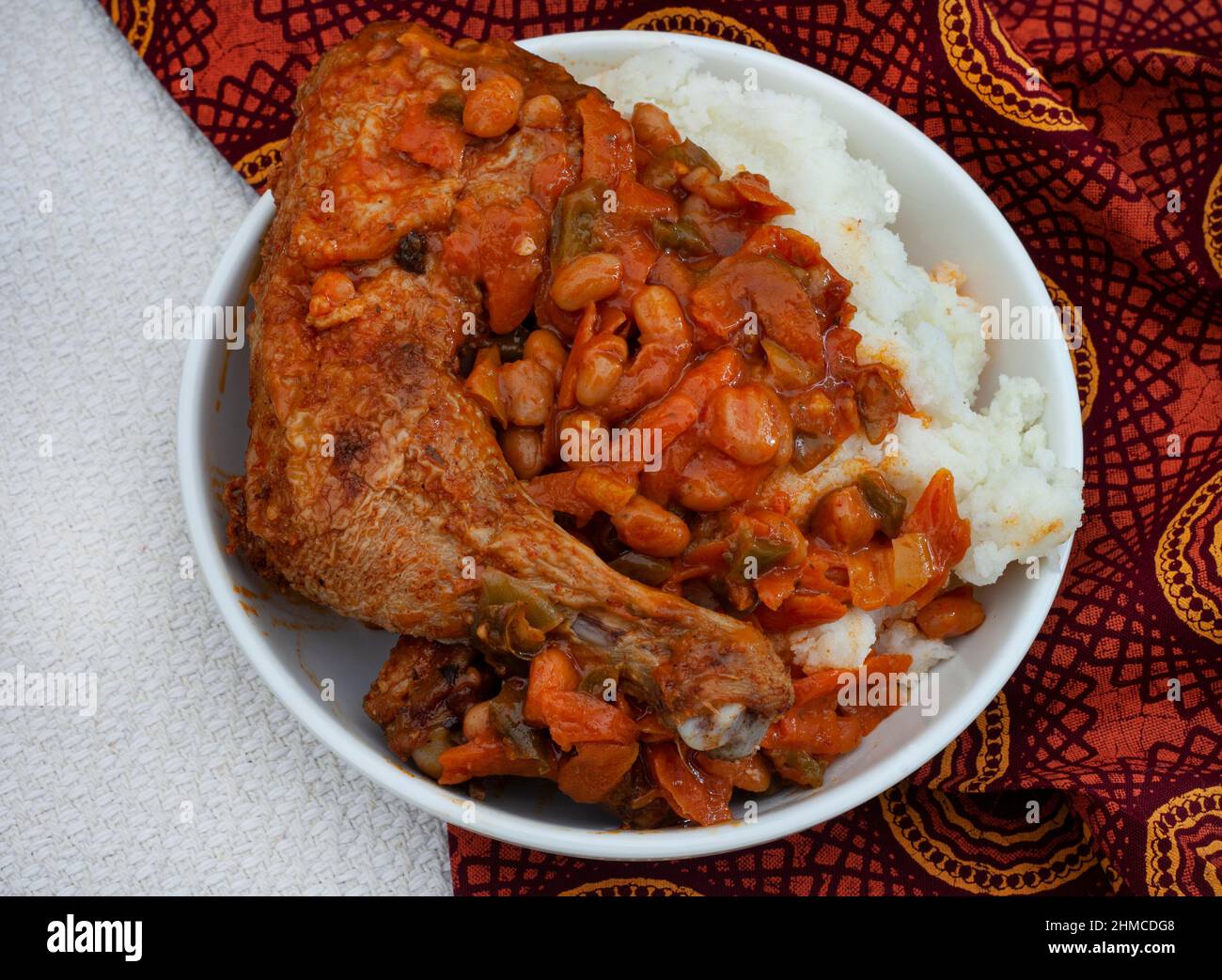 Traditionelles südafrikanisches Pap und gebratenes Huhn, Maismehl mit Hühnerstück und Chakalaka-Sauce Stockfoto