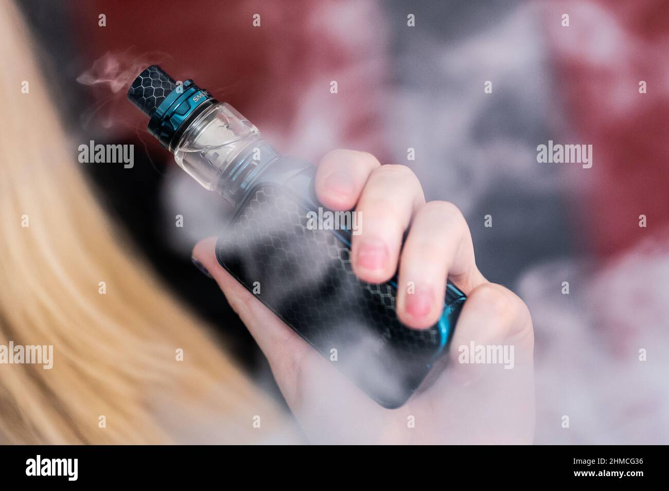 PRODUKTION - 07. Februar 2022, Baden-Wrttemberg, Bsingen: ILLUSTRATION -  Eine junge Frau raucht mit einer E-Shisha in ihrer Wohnung. Foto: Silas  Stein/dpa Stockfotografie - Alamy