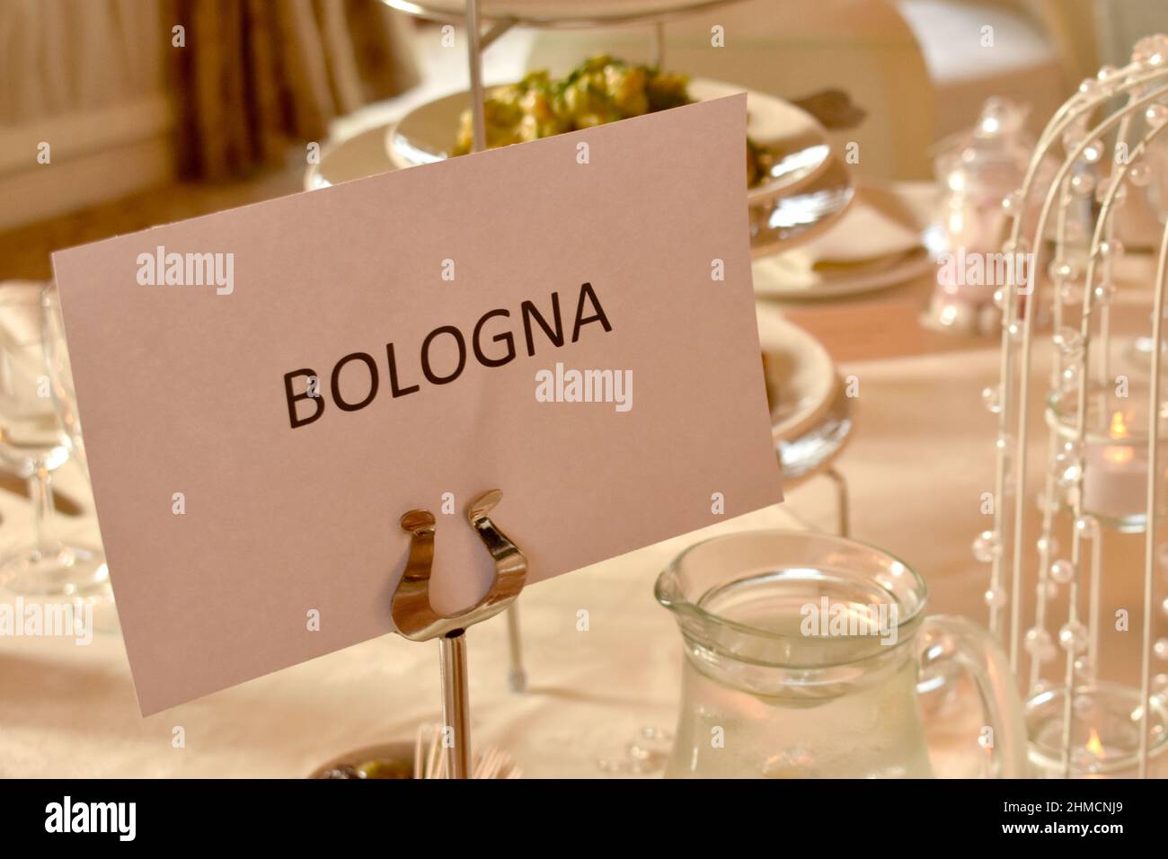 Nahaufnahme des aufgedruckten Namensschilds, der italienischen Stadt Bologna auf einem Esstisch, für eine Hochzeitsfeier Stockfoto