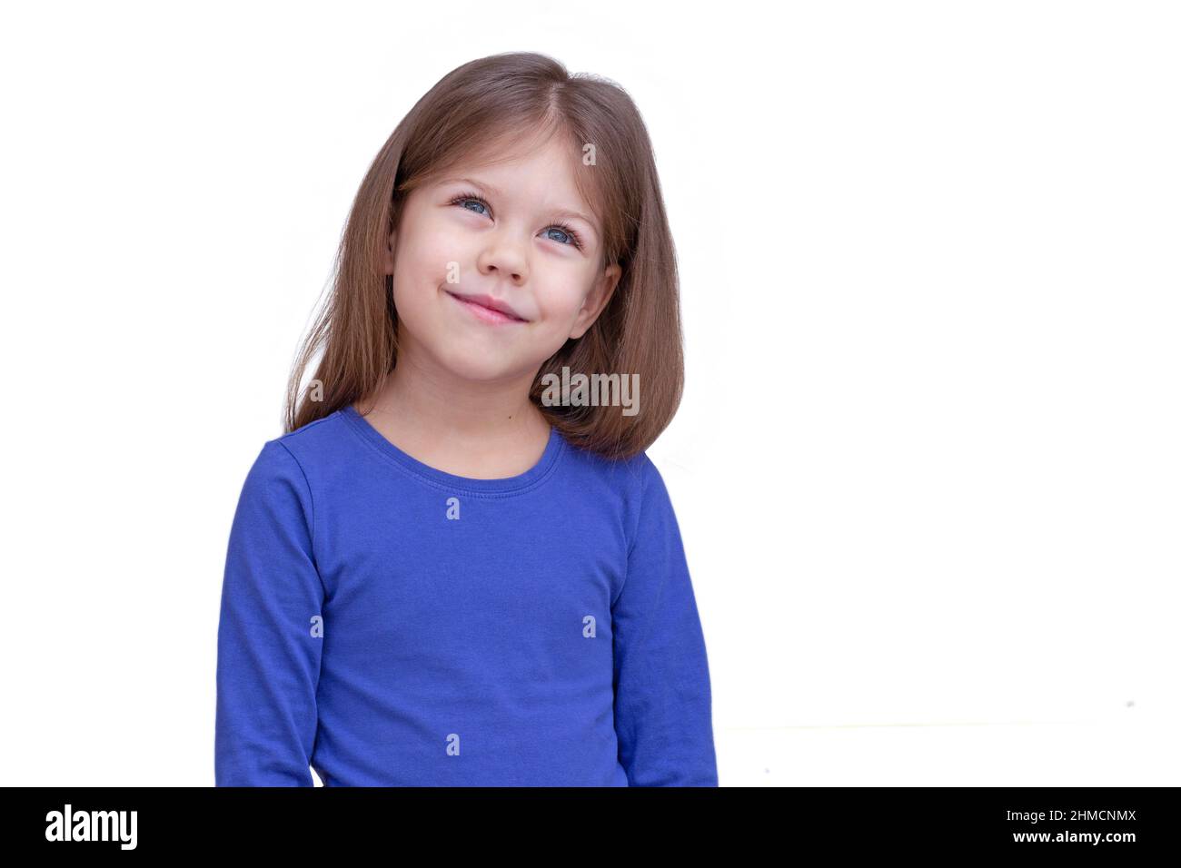 Träumen lächelnd glücklich Kind Kind isoliert auf weißem Hintergrund, Blick bis Taille kaukasischen kleinen Mädchen von 5 Jahren in blau Stockfoto