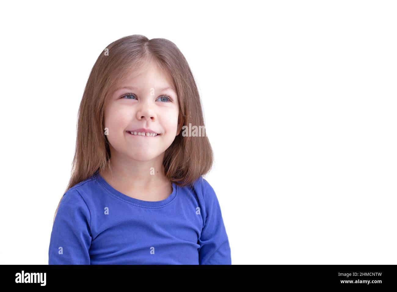 Träumen lächelnd glücklich beißen Lippenkind Kind isoliert auf weißem Hintergrund, Blick beiseite Taille bis kaukasischen kleinen Mädchen von 5 Jahren in blau Stockfoto