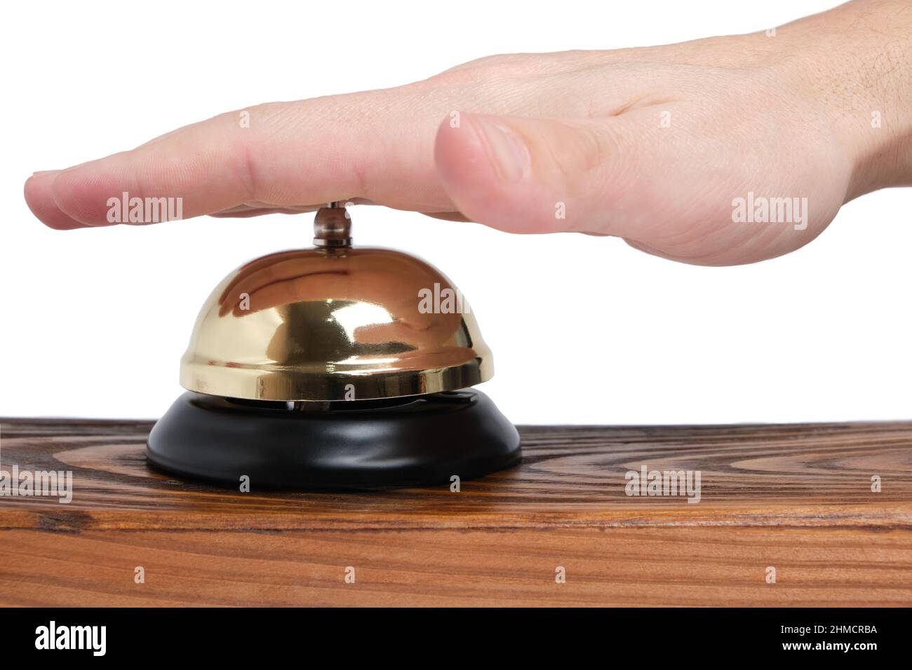 Drücken Sie Ihre Hand auf die Glocke des Hotelservices auf weißem Hintergrund.Konzept Hotel, Reise und Urlaub Stockfoto