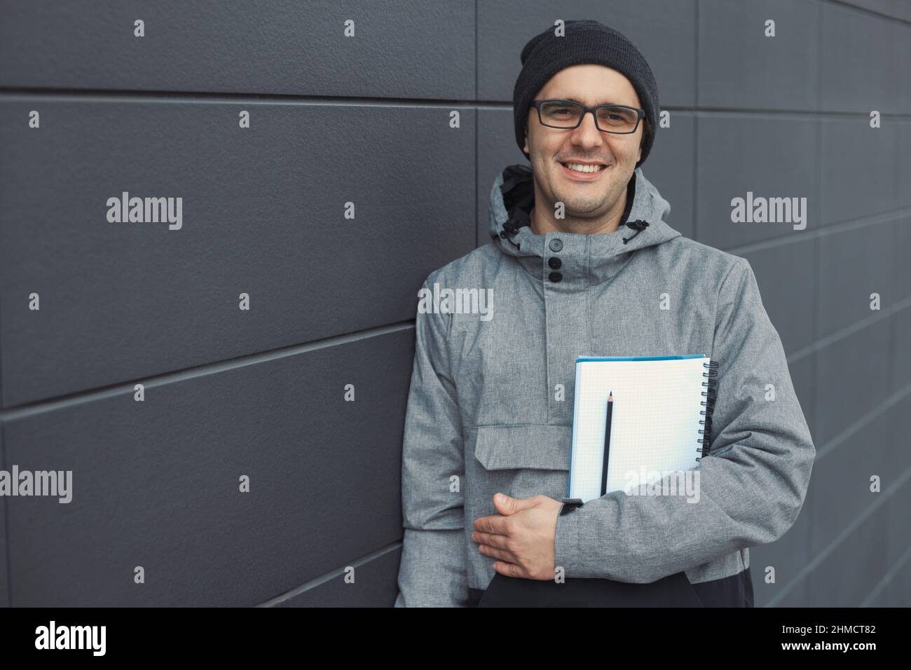 Nahaufnahme Porträt eines hübschen 30-35 Jahre alten Mannes im Freien, der in der Nähe der Wand steht Stockfoto