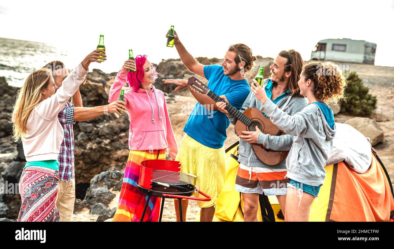 Indie Leute haben Spaß auf Strand Camping Party - Wanderlust Reise Lifestyle-Konzept mit glücklichen Freunden Reisende jubeln zusammen mit Bier und gui Stockfoto