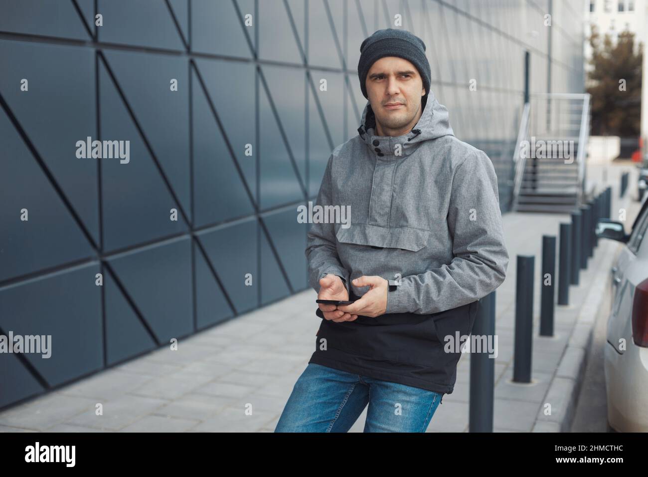 Porträt eines schönen 30-35 Jahre alten Mannes im Straßenstil im Freien in der Nähe der Wand Stockfoto