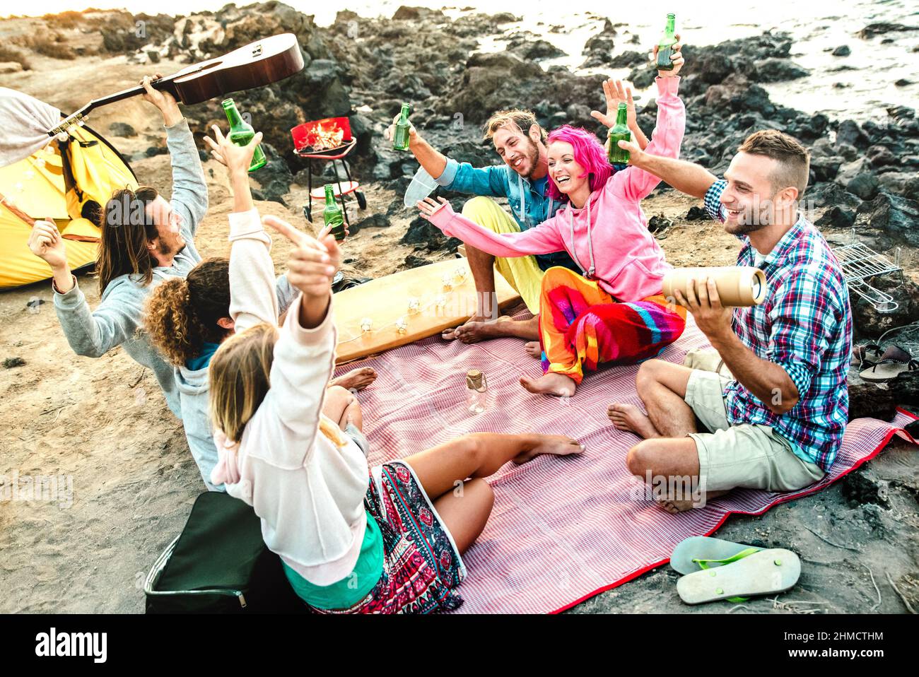 Alternative Freunde, die zusammen Spaß am Strand Camping Party - Life style Reisekonzept mit glücklichen Menschen Reisende toasten und trinken abgefüllt b Stockfoto