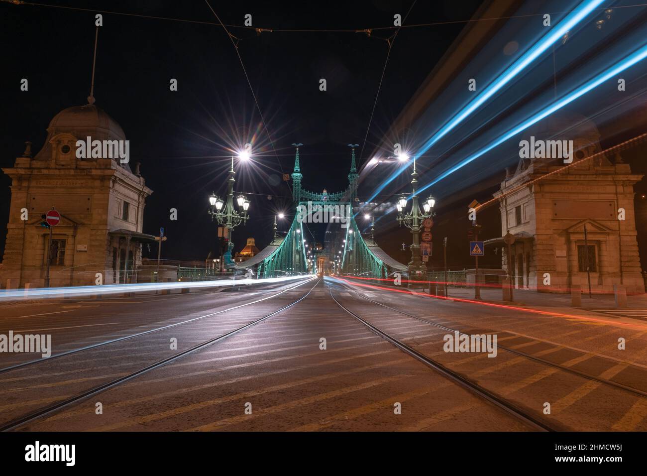 Leichte Wege von Fahrzeugen auf der Freiheitsbrücke bei Nacht in Budapest, Ungarn Stockfoto