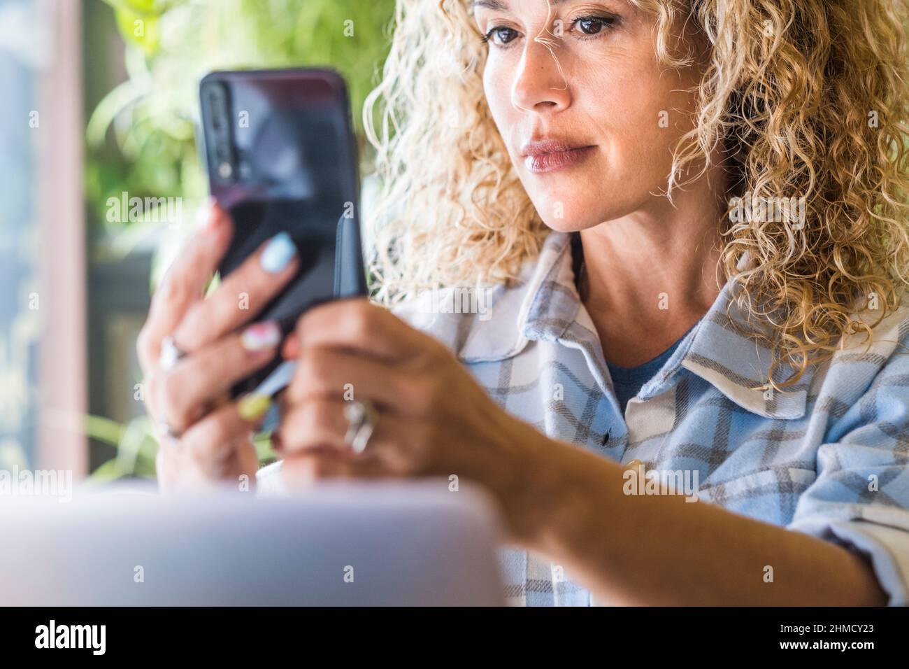 Attraktive kaukasische Erwachsene Frau verwenden Mobiltelefon als Spiegel, um Make-up Schönheit zu überprüfen. Moderne weibliche Menschen, die Videokonferenzen mit Mobilfunk führen Stockfoto
