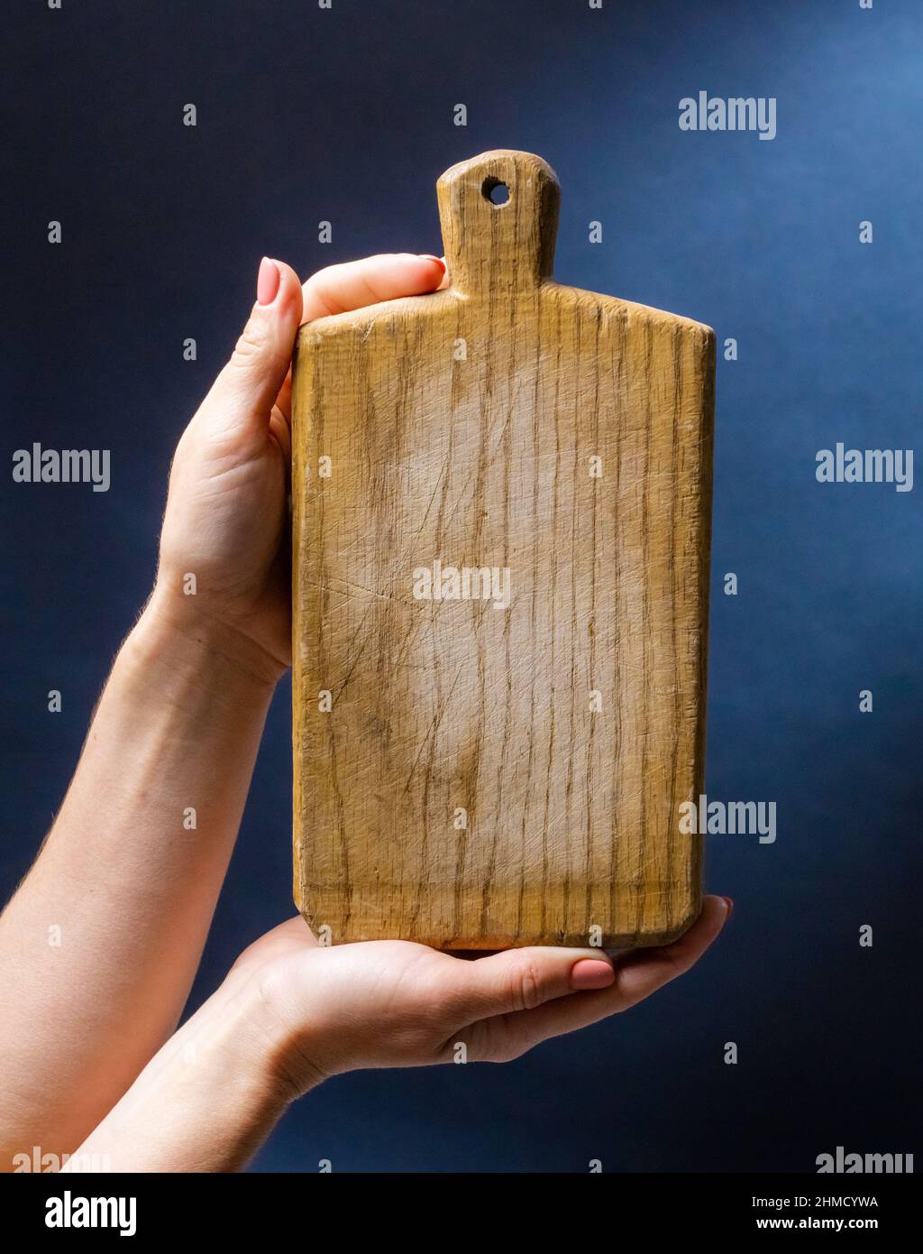 Hand hält Küchenbrett Stockfoto