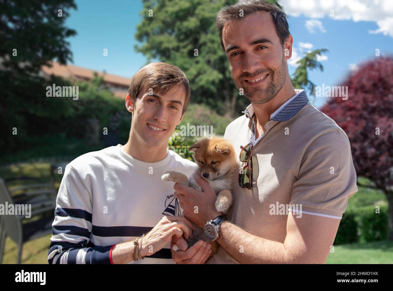 Zwei junge Männer, schwules Paar mit ihrem Welpen, shiba Inu Hund - Outdoor Stockfoto