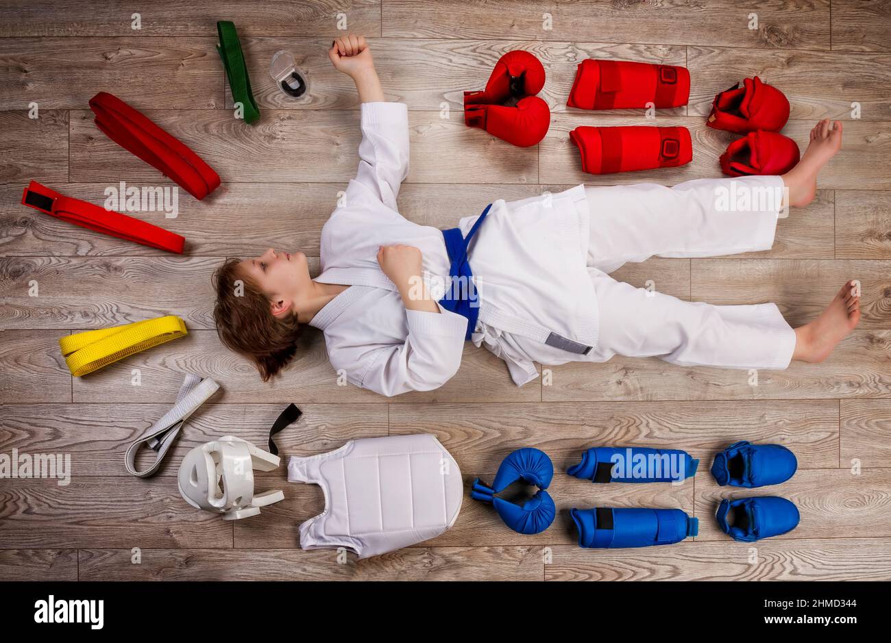 Konzeptuelles Bild im flachen Lay-Stil eines kleinen Karateka-Mädchens, umgeben von ihrer Ausrüstung, die für Training und Wettkampf notwendig ist Stockfoto