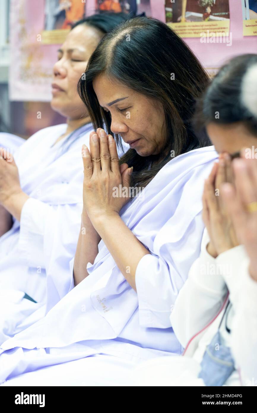 Buddhistische Frauen beten, während sie weiße Roben tragen. In einem Tempel in Elmhurst, Queens, New York City. Stockfoto