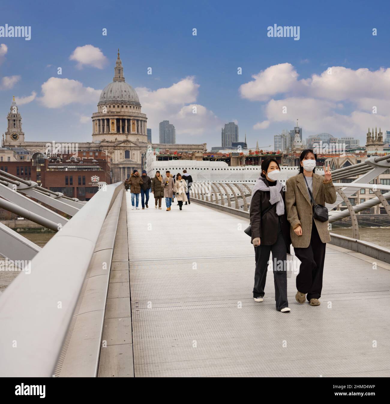 Touristen auf der Millenium Bridge, London, Friedenssymbol, mit Masken Stockfoto