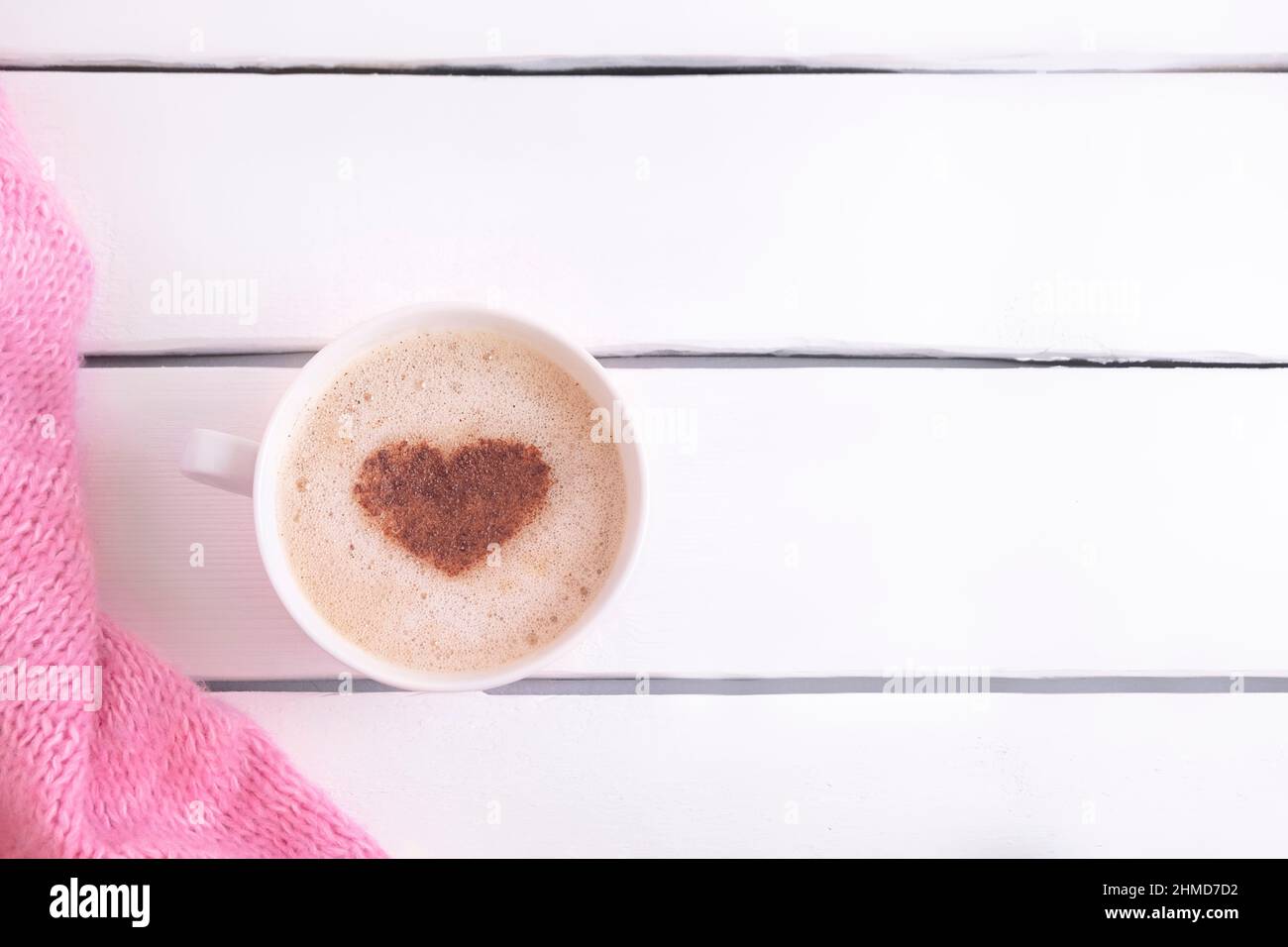 Romantische Komposition mit Kaffeebecher mit Zimt-Herzform auf weißem Holztisch mit Platz für Text, Draufsicht. Valentinstag Stockfoto