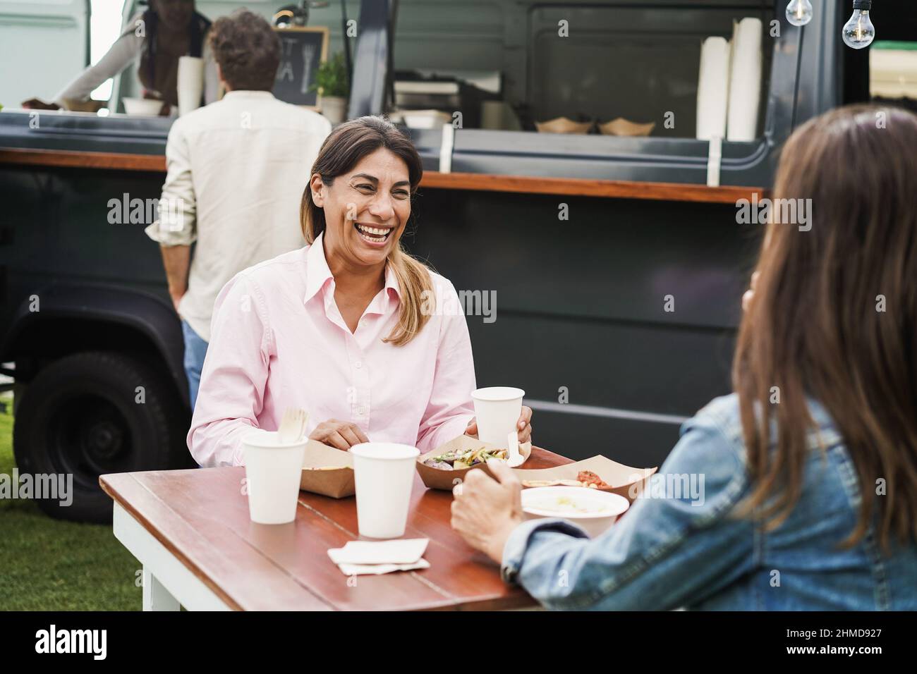 Ältere Frauen essen im Food Truck Restaurant im Freien - Konzentrieren Sie sich auf das linke weibliche Gesicht Stockfoto