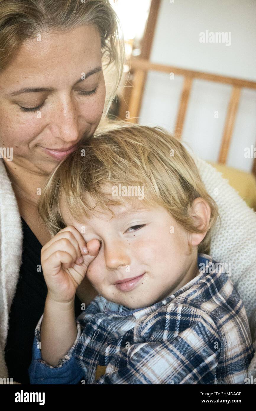 Schöne Frau trägt lächelnden kleinen Sohn zu Hause Stockfoto