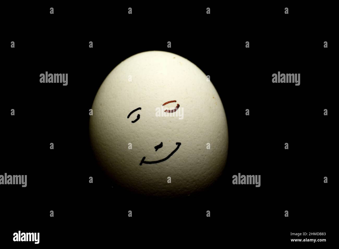 Ei stellen Lächeln menschlichen Gesicht isoliert vor schwarzem Hintergrund Stockfoto