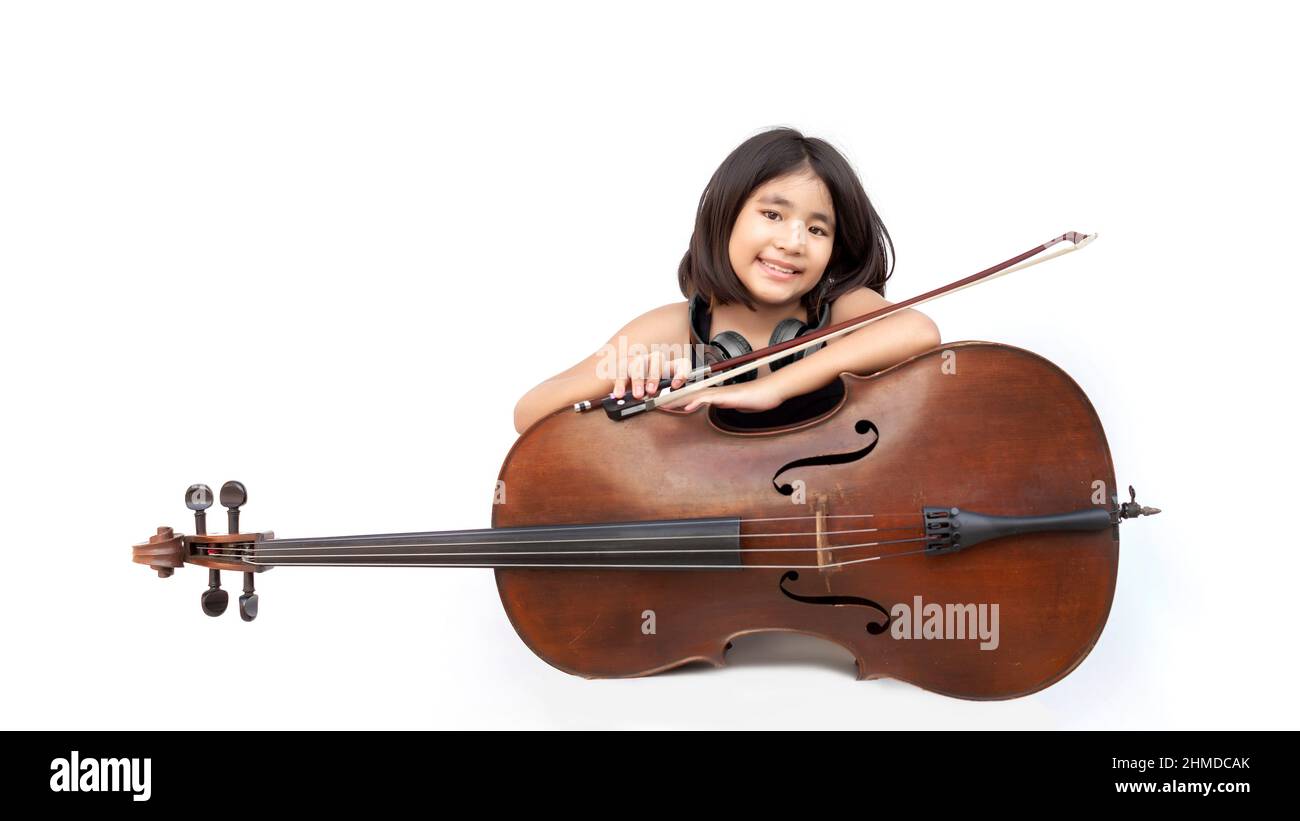 Portrait Asian Kind Liebe klassische Musik mit Cello-Saiteninstrument und Kopfhörer auf weißem isolierten Hintergrund. Musikpädagogik Konzept auf Bannergröße Stockfoto