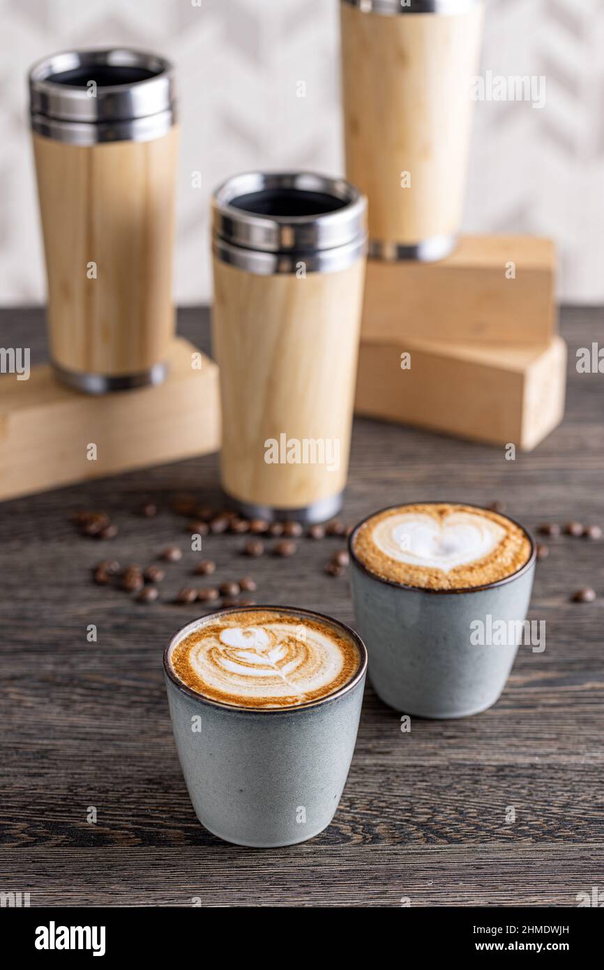 Zwei Tassen Cappuccino mit Latte Art auf einem Holztisch Stockfoto