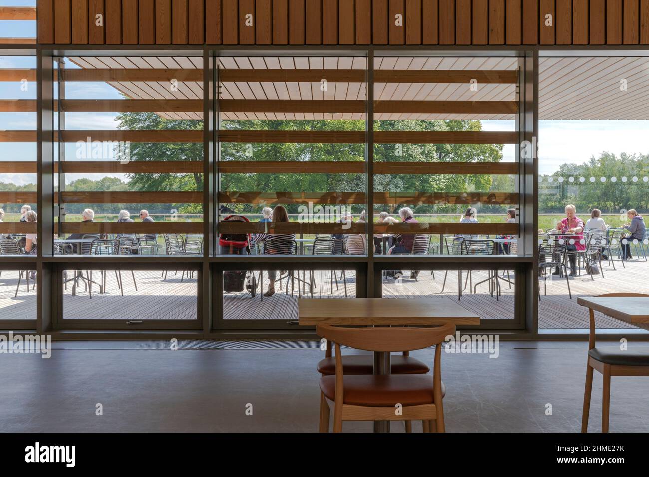 Blick auf die Café-Sitzgelegenheiten im Freien. Besucherzentrum Der Royal Horticultural Society, Worsley, Salford, Großbritannien. Architekt: Hodder & Partners, 2021. Stockfoto