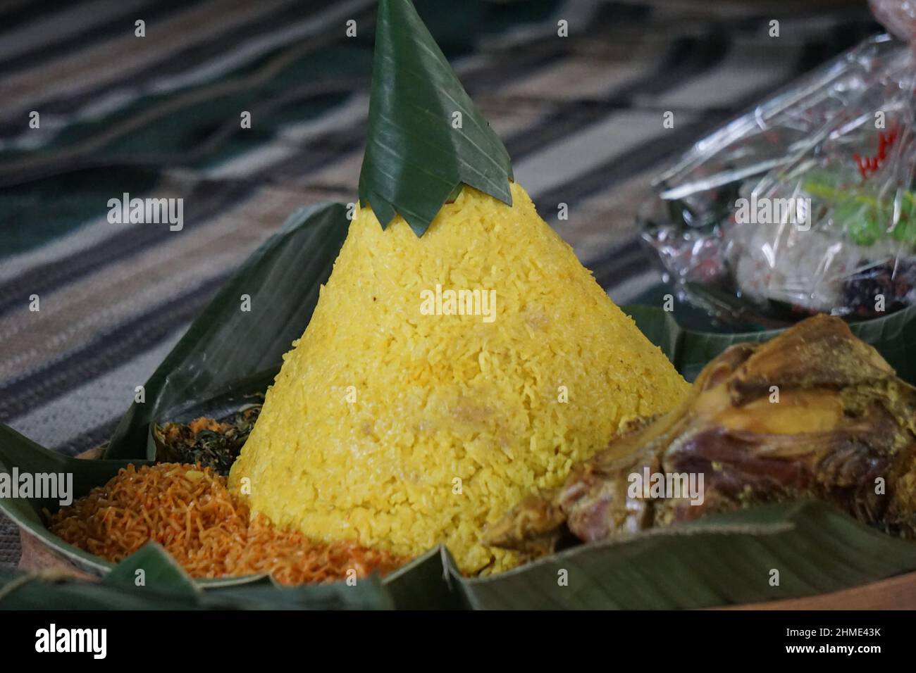 Indonesisches Dankesmenü mit dem Namen Nasi tumpeng (Reis mit Kegelform). Nasi tumpeng essen in der Regel auf Geburtstagsparty, Abschlussfeier oder Danksagn Stockfoto