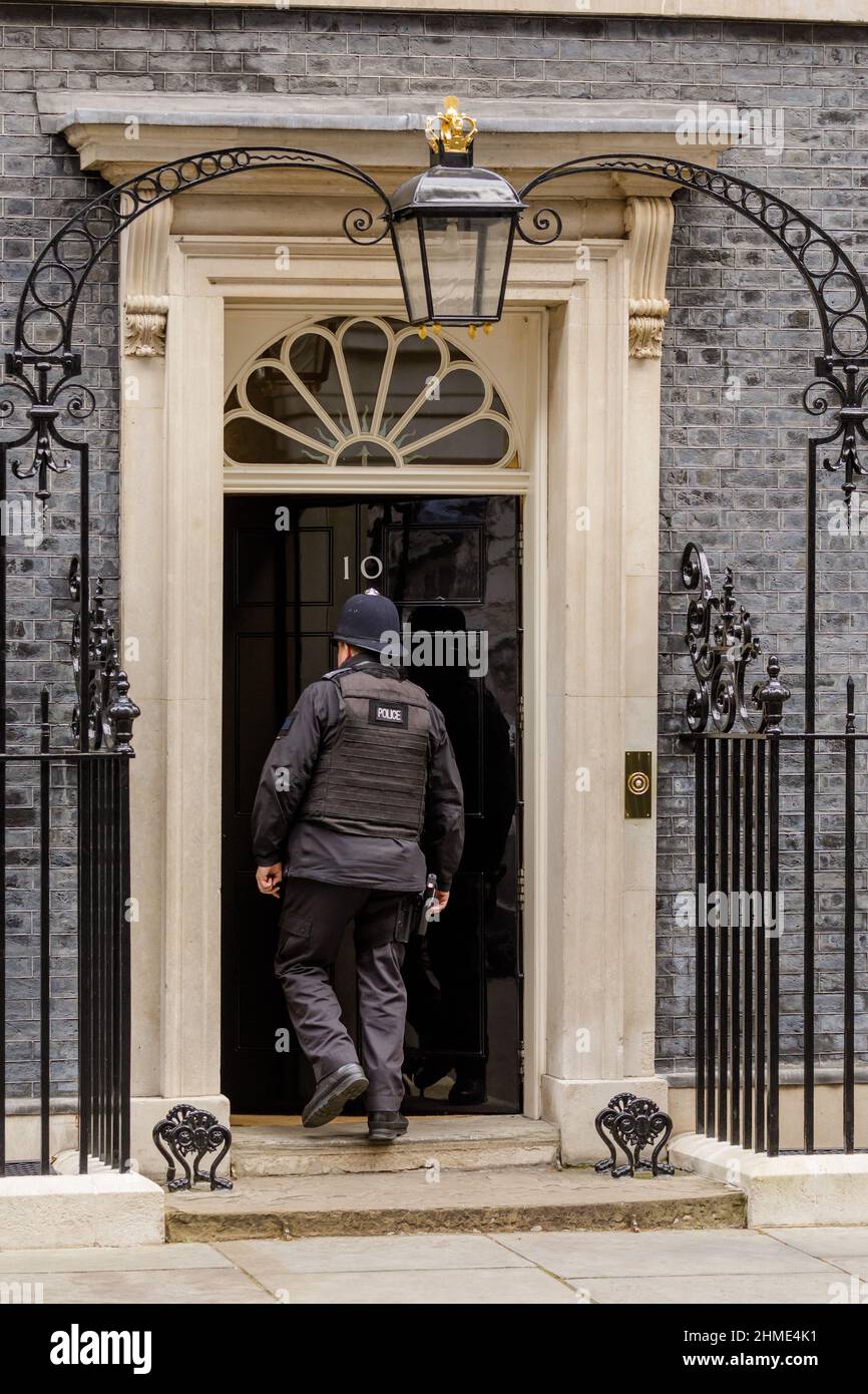 Polizeibeamter, der die berühmte schwarze Tür in der Downing Street Nr. 10, London, Großbritannien, betrat Stockfoto